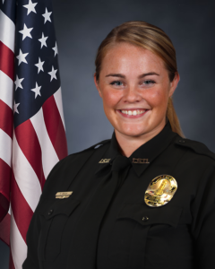 Officer Natasha Greene in uniform with USA flag in background
